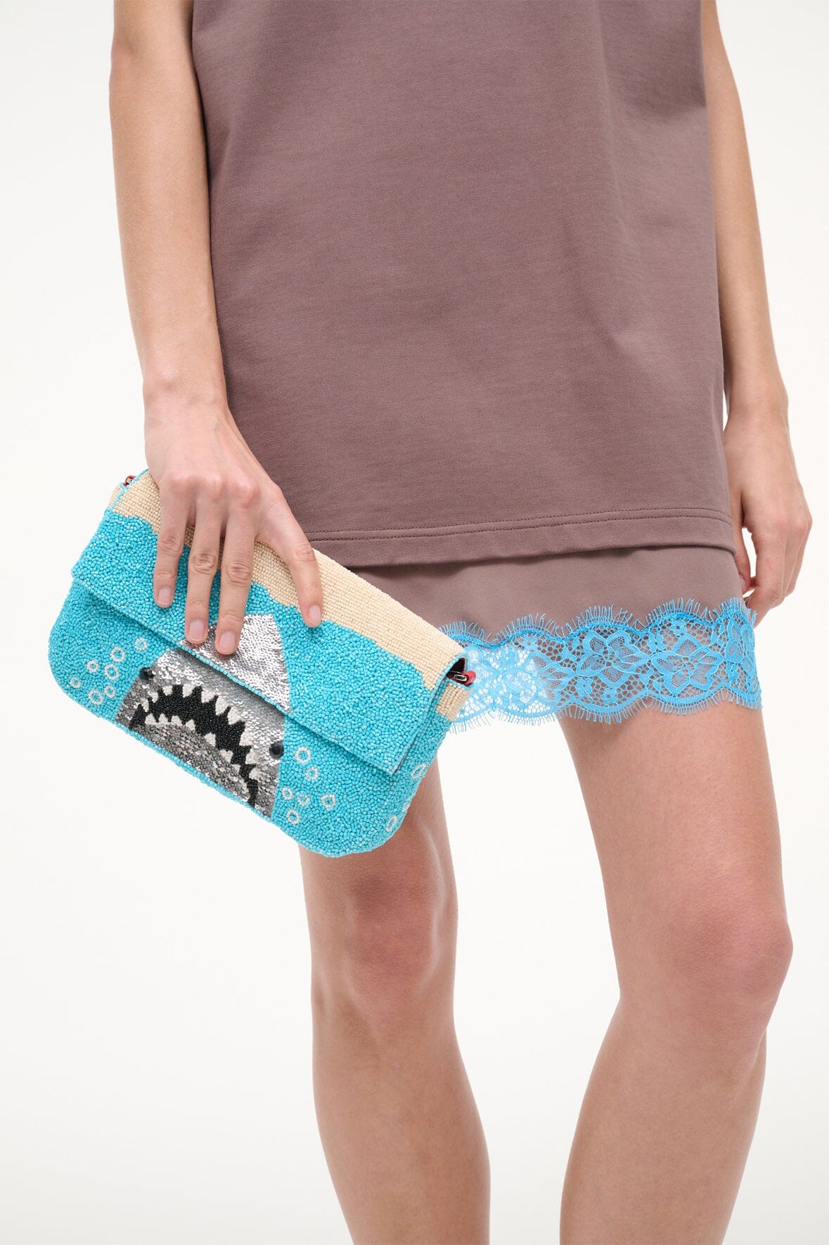 Turquoise sequin shoulder bag close grip on strap with shark face graphic.