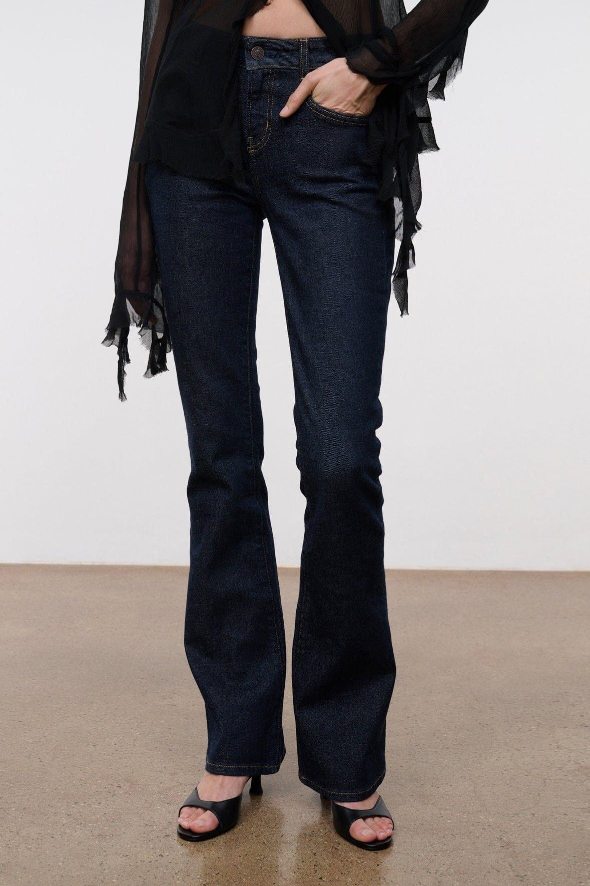 Indigo stretch flare jeans on model with high-rise fit and stitched front seams