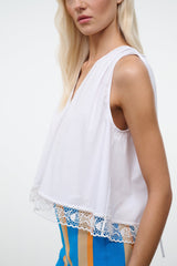 White sleeveless V-neck top with lace hem trim at bottom edge