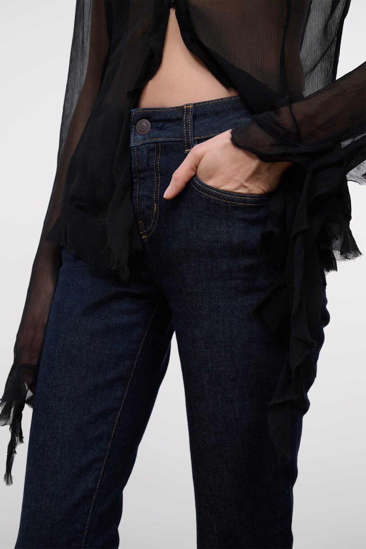 Indigo stretch jeans close-up of waistband and front pocket with hand inside pocket