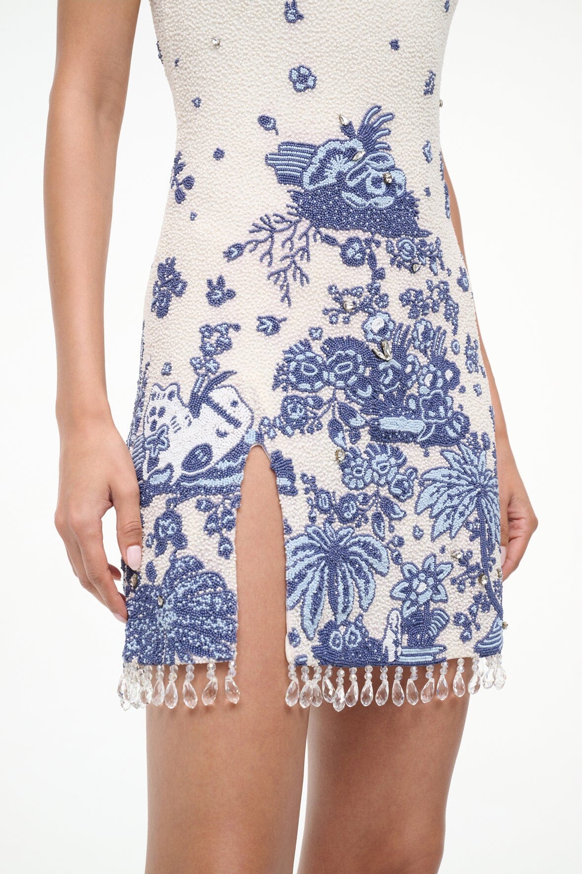 Blue toile shift dress hem detail with front slit and white tassel fringe
