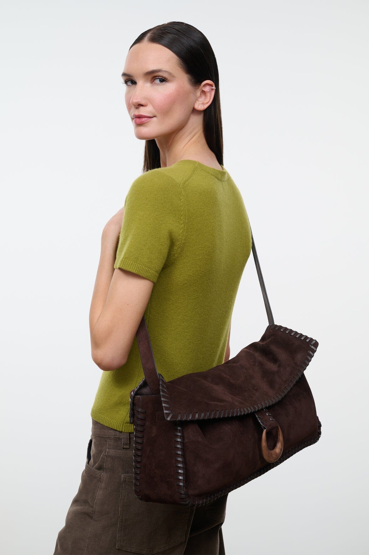 Espresso brown suede messenger bag with curved flap and wide shoulder strap.
