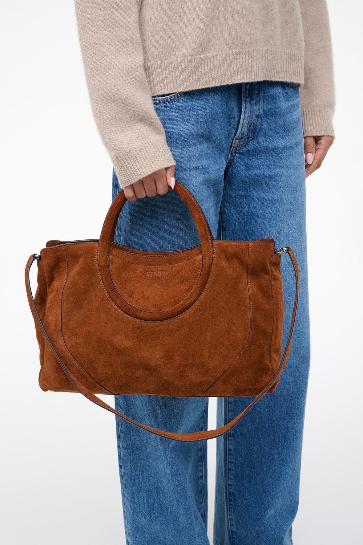Brown suede satchel on shoulder, double top handles and crossbody strap, structured shape