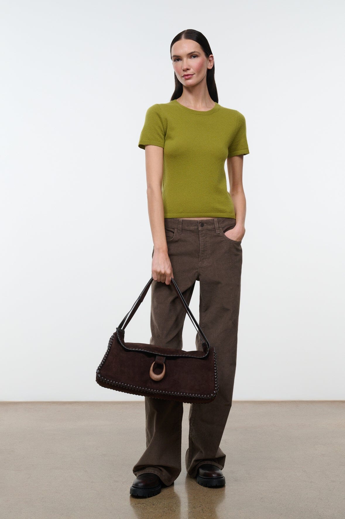 Espresso brown messenger bag with top flap and crossbody strap, worn at front.