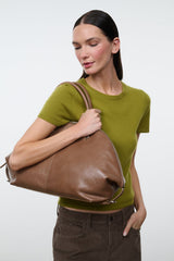 Brown leather satchel bag with top handles and zip closure, side view