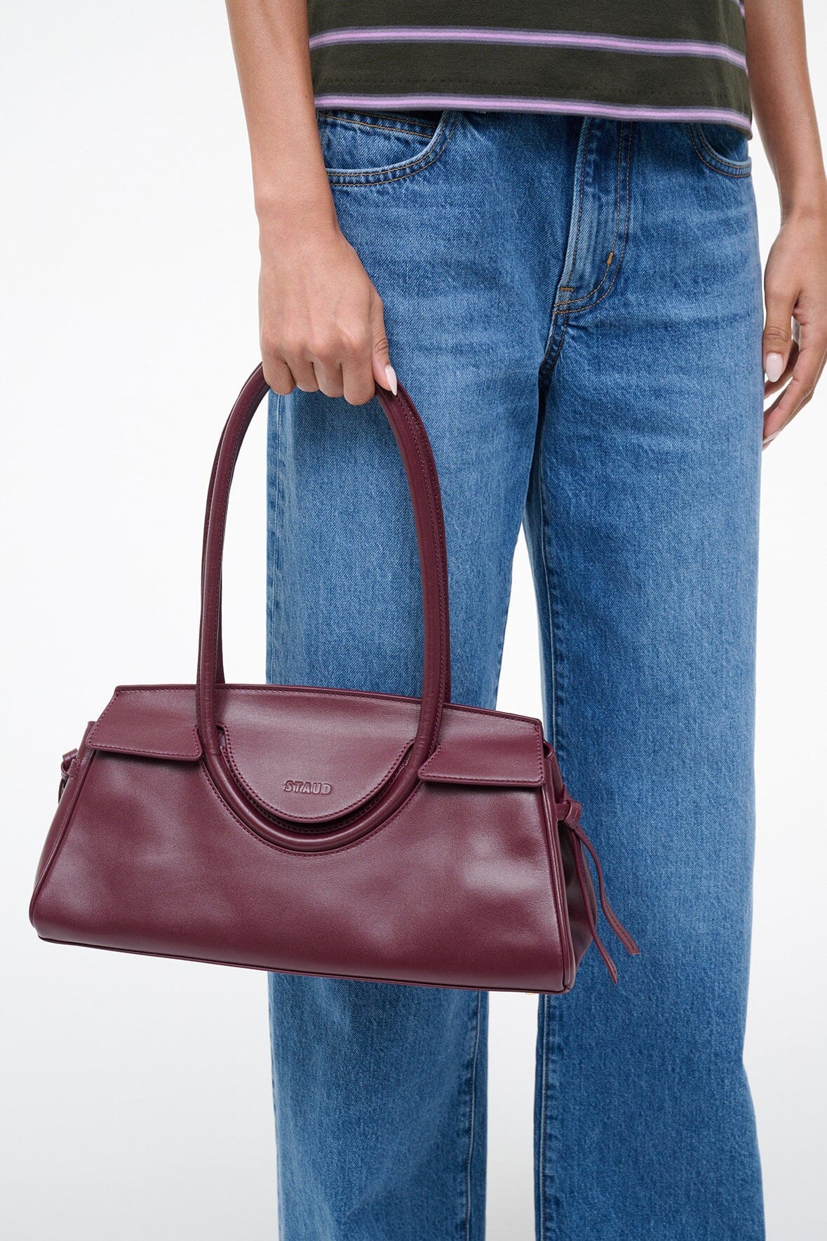 Maroon leather shoulder bag held by curved handles with side bows