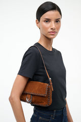 Espresso suede shoulder bag on model with metal clasp and stitched edging