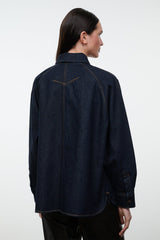 Indigo denim shirt jacket back view with yoke seam, buttoned cuffs, and contrast stitching