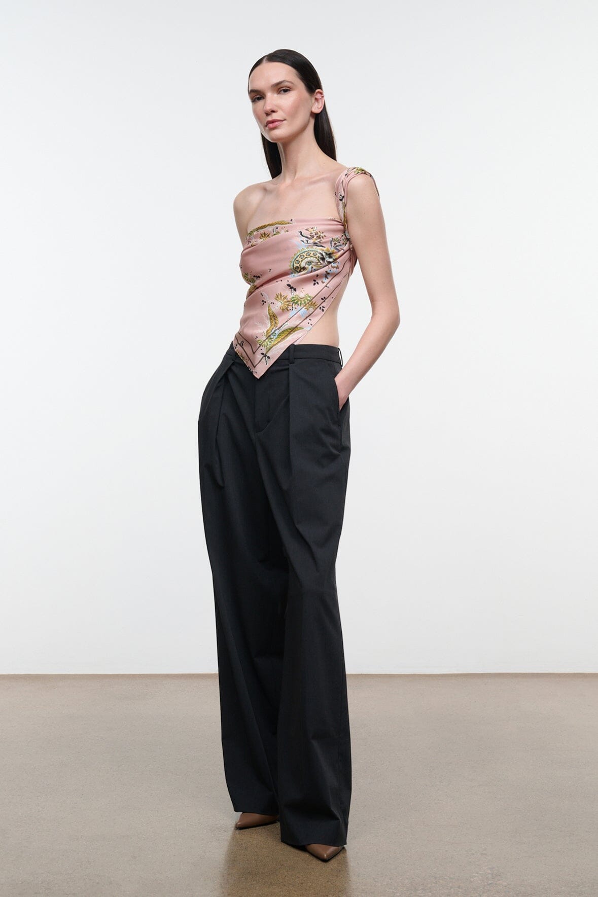 Silk scarf draped as one-shoulder top, pink floral paisley print with decorative medallion.