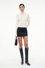 Ivory cashmere turtleneck sweater, long sleeves, ribbed collar and cuffs.