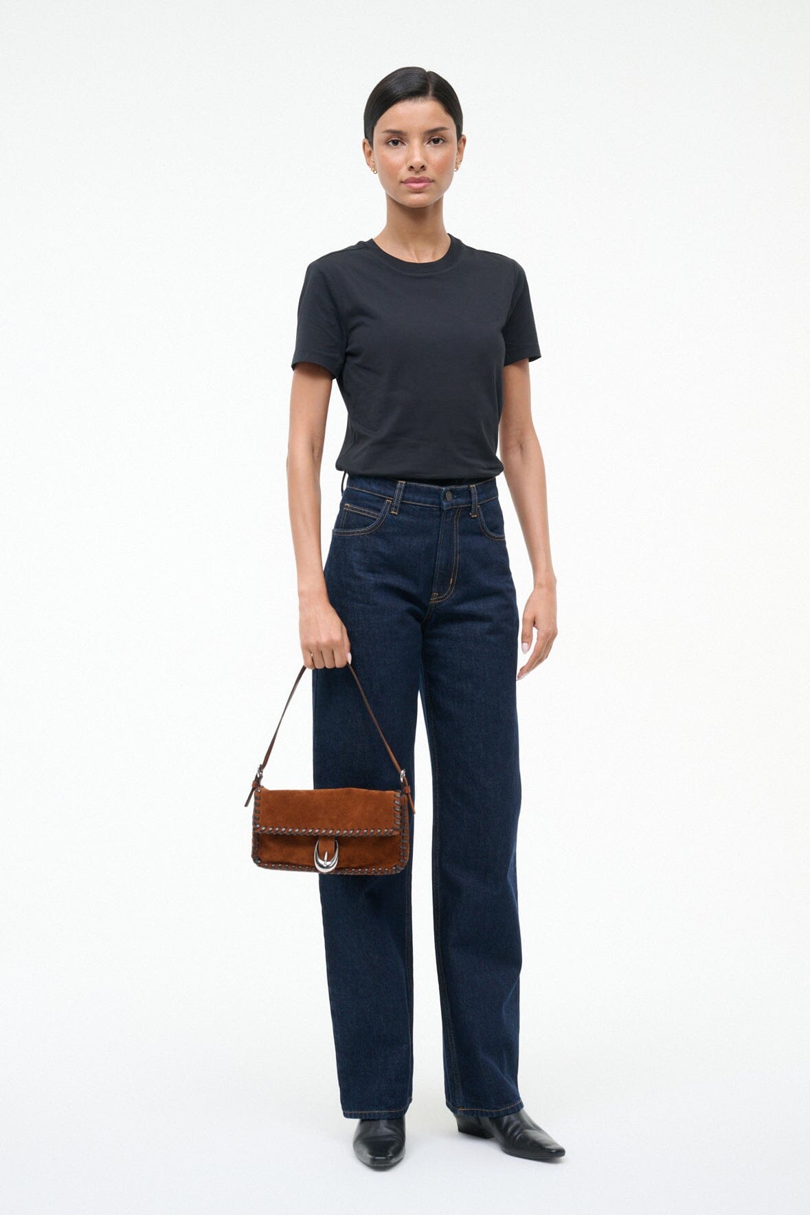Espresso suede shoulder bag worn by model with braided trim and metal clasp