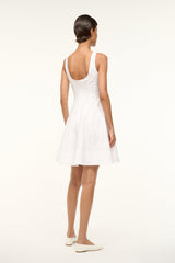 White sleeveless mini dress with open back and flared skirt