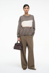 Taupe crewneck sweater with white sheep graphic and ribbed cuffs; long sleeves