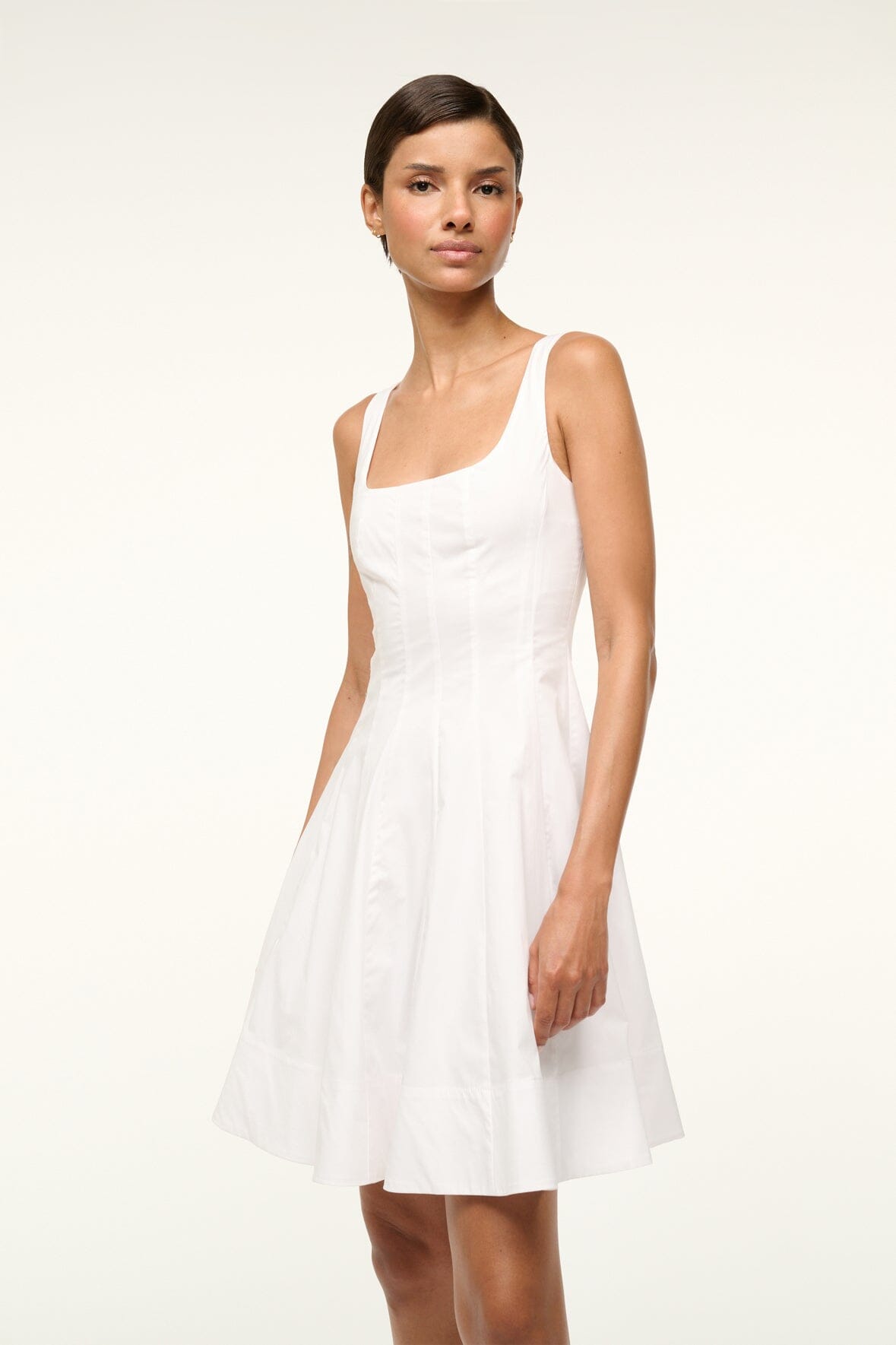 White sleeveless mini dress with square neckline and pleated A-line skirt