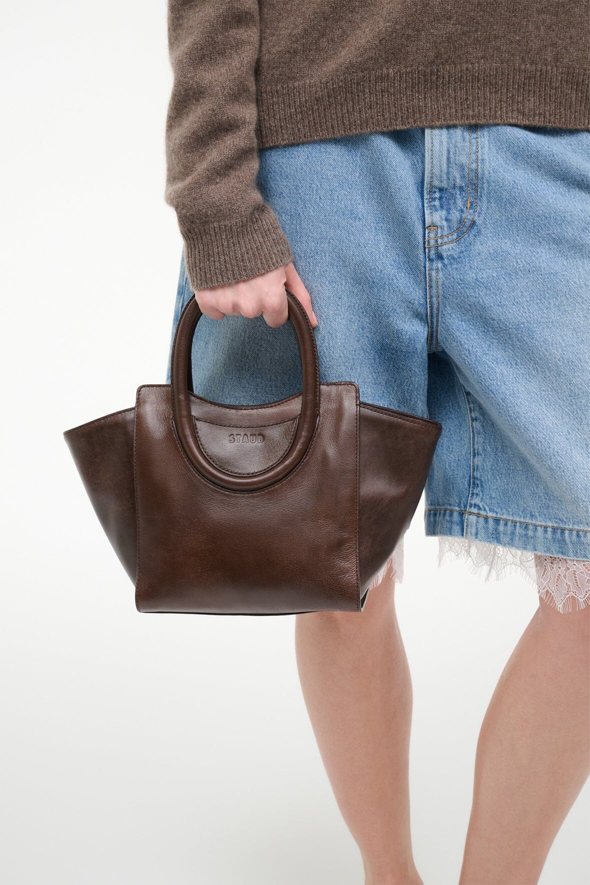 MAUDE mini tote held at side, espresso distressed brown with dual top handles