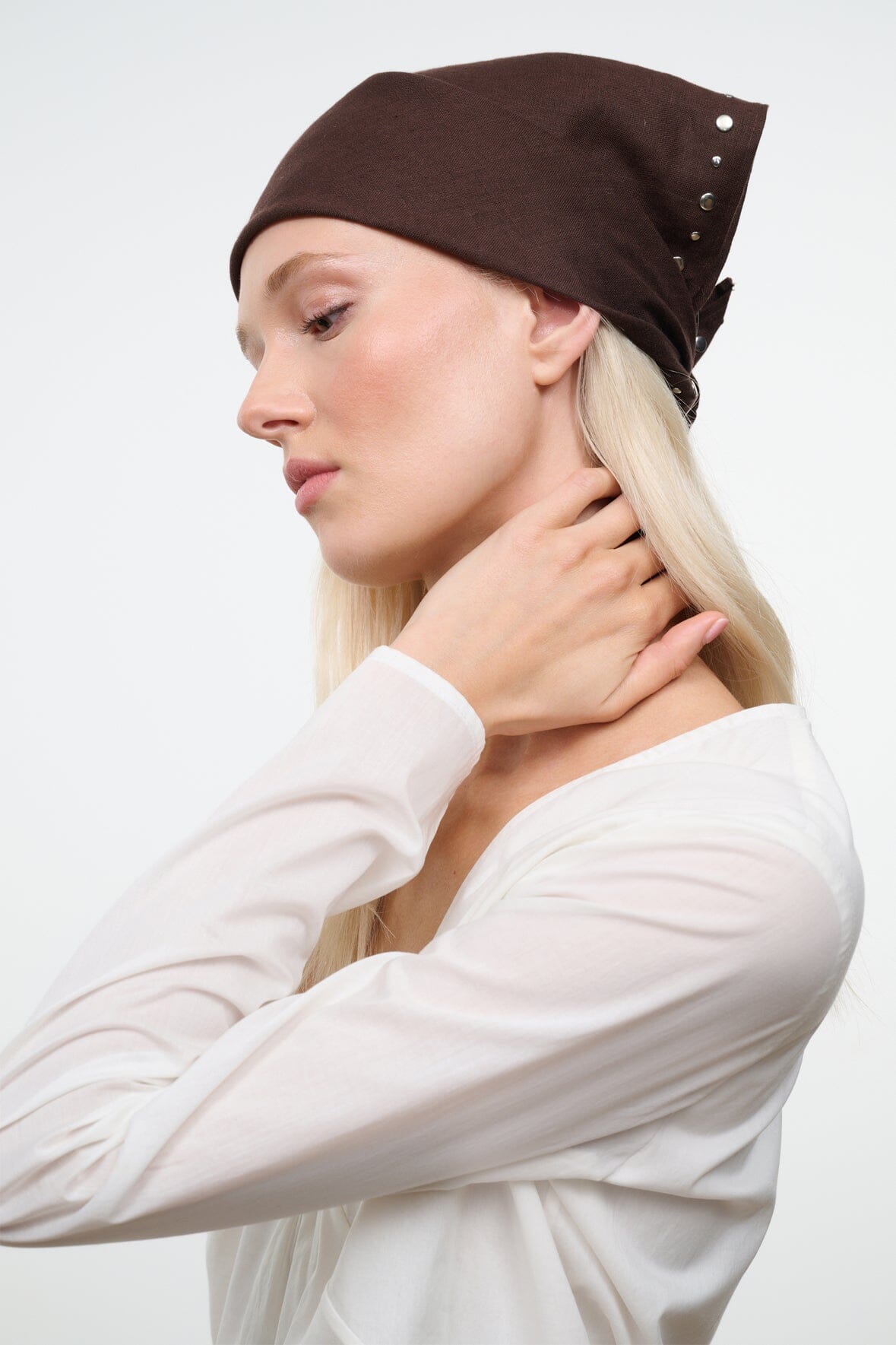 Brown headscarf with silver studs and tied bow at back, worn with long hair