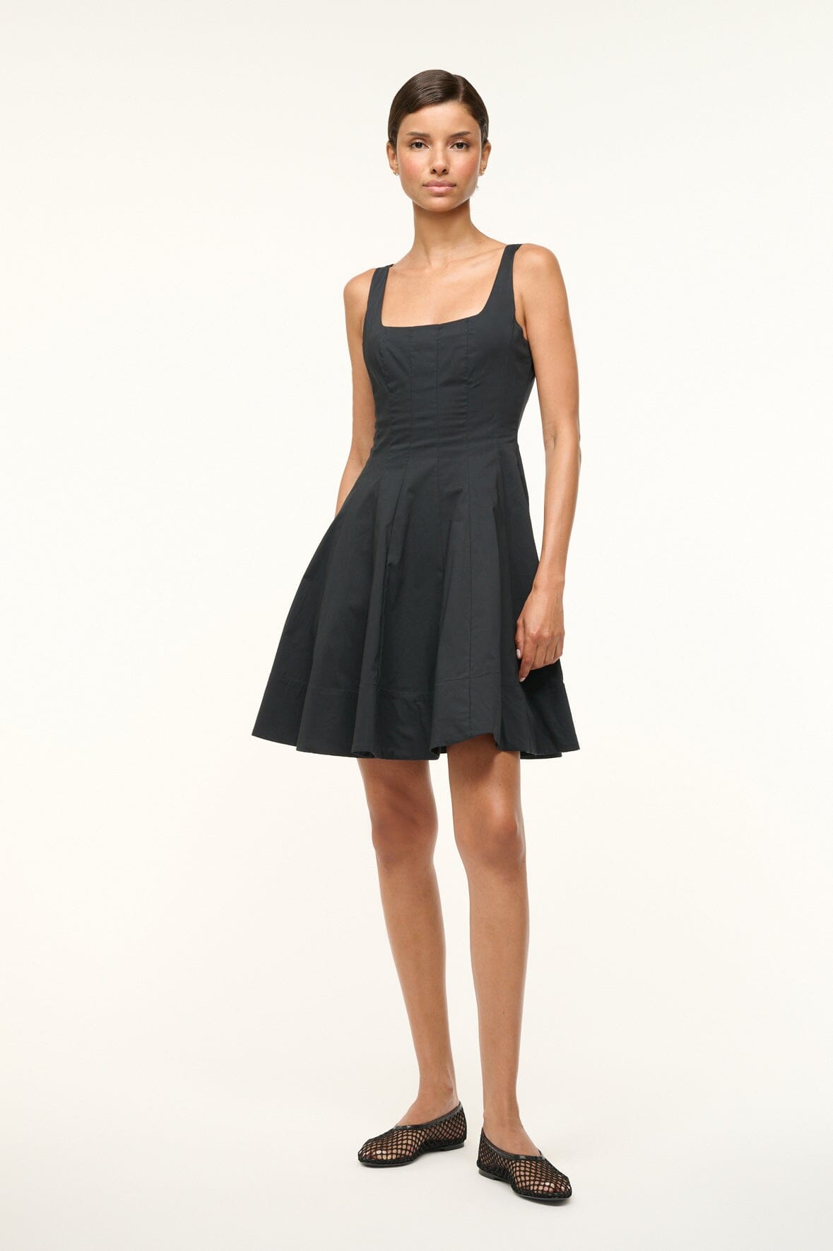 Black sleeveless mini dress with square neckline and pleated A-line skirt
