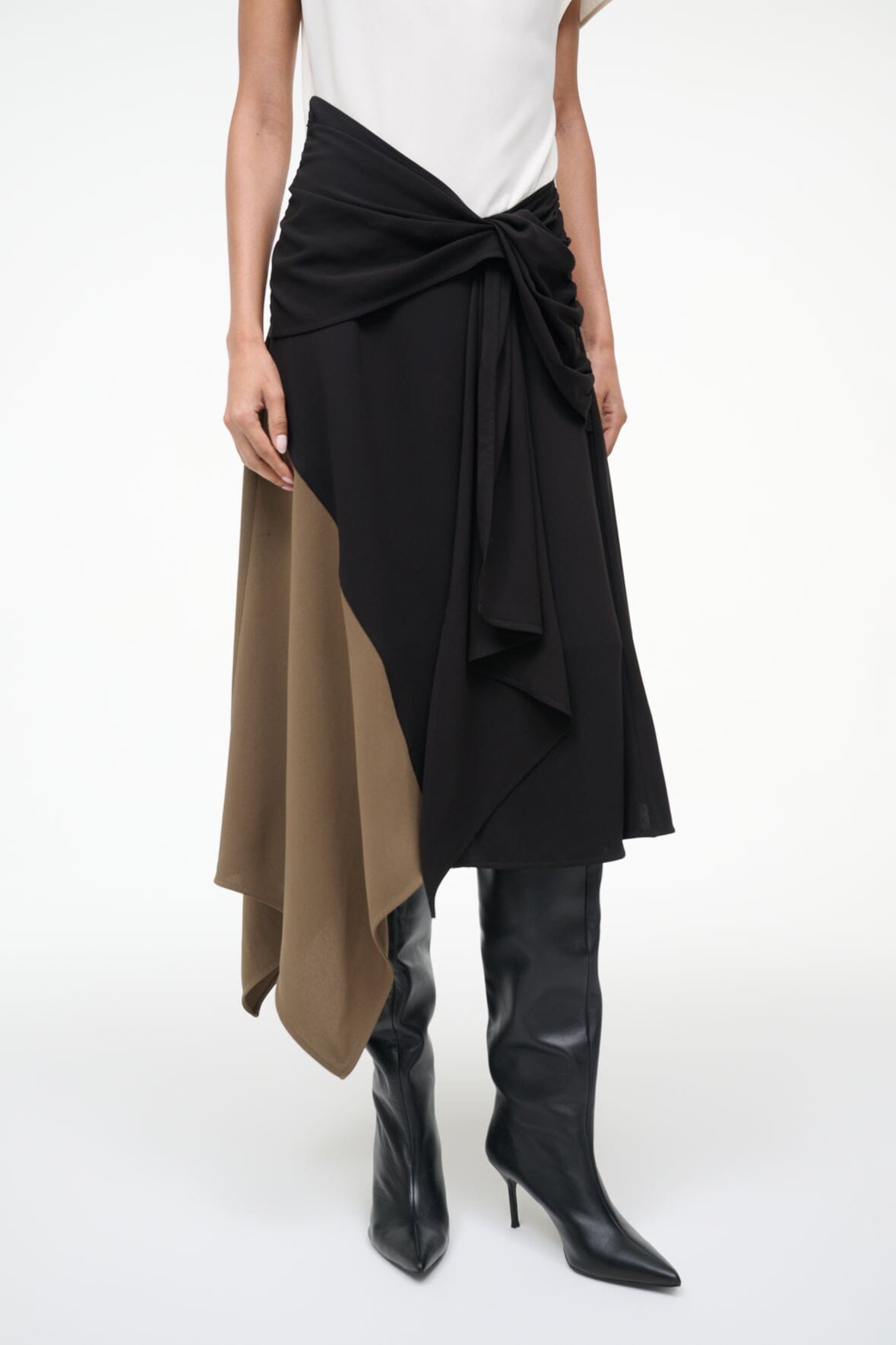 Sleeveless dress with knotted waist drape, black skirt panel over tan asymmetric panel