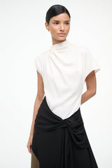 Sleeveless high-neck dress with white upper, black bow-tied waist and draped skirt