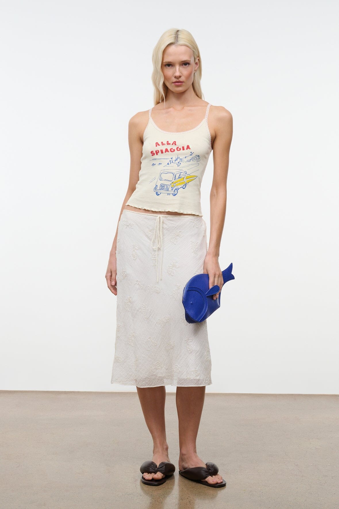 Cream sleeveless graphic camisole top with red-blue seaside artwork front