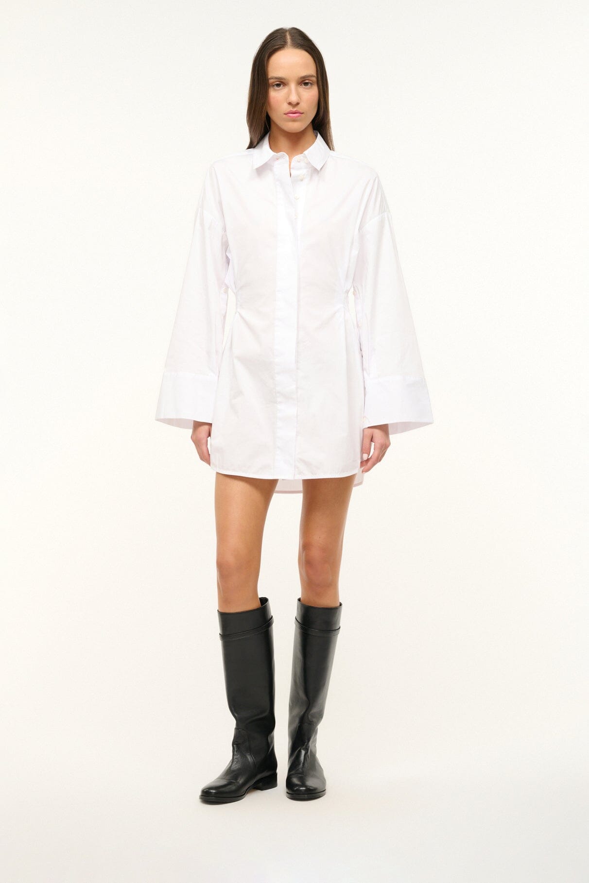 Black riding boots worn with short dress, front view