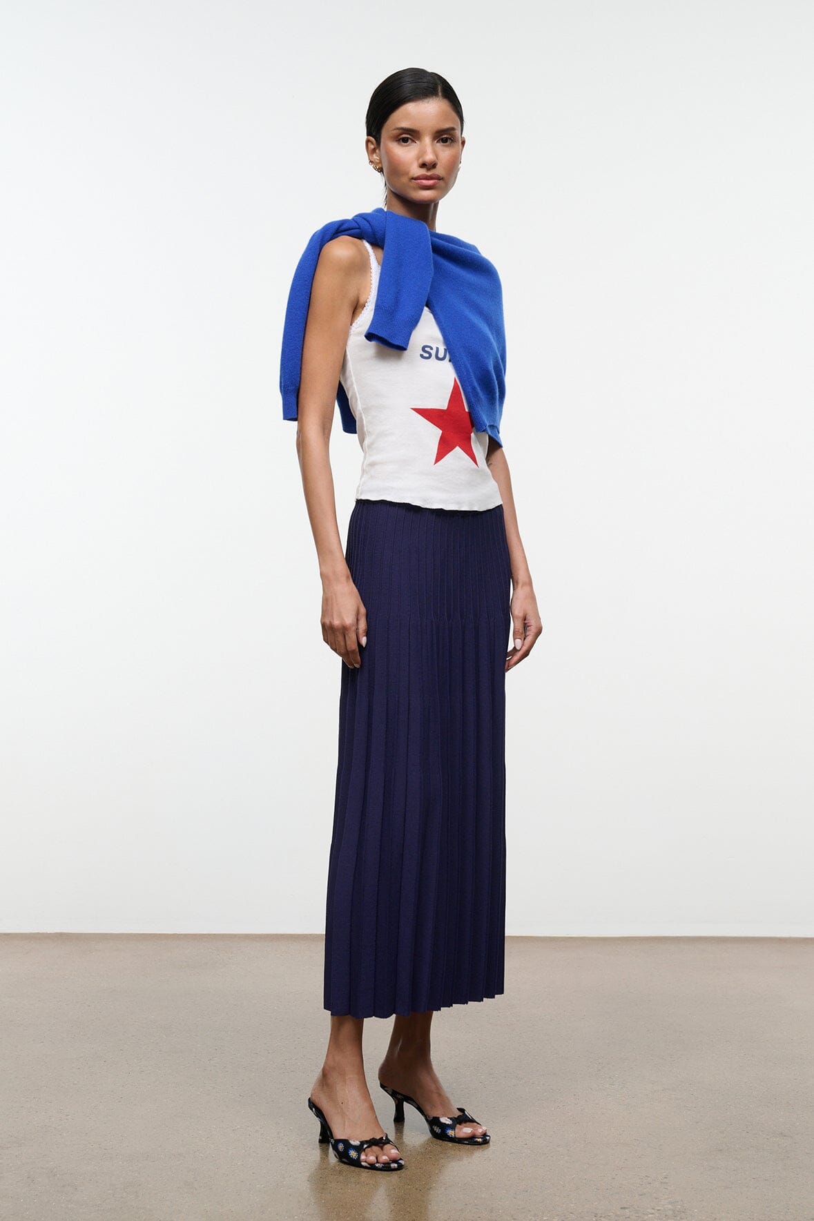 Floral black mule shoes with low kitten heel, worn with a navy pleated skirt