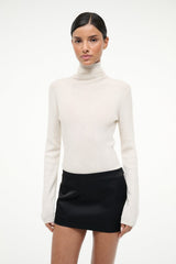 Ivory cashmere turtleneck sweater with long sleeves and fitted silhouette.