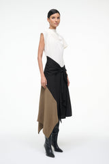 Sleeveless high-neck dress, side view, white top with black wrap drape over tan panel