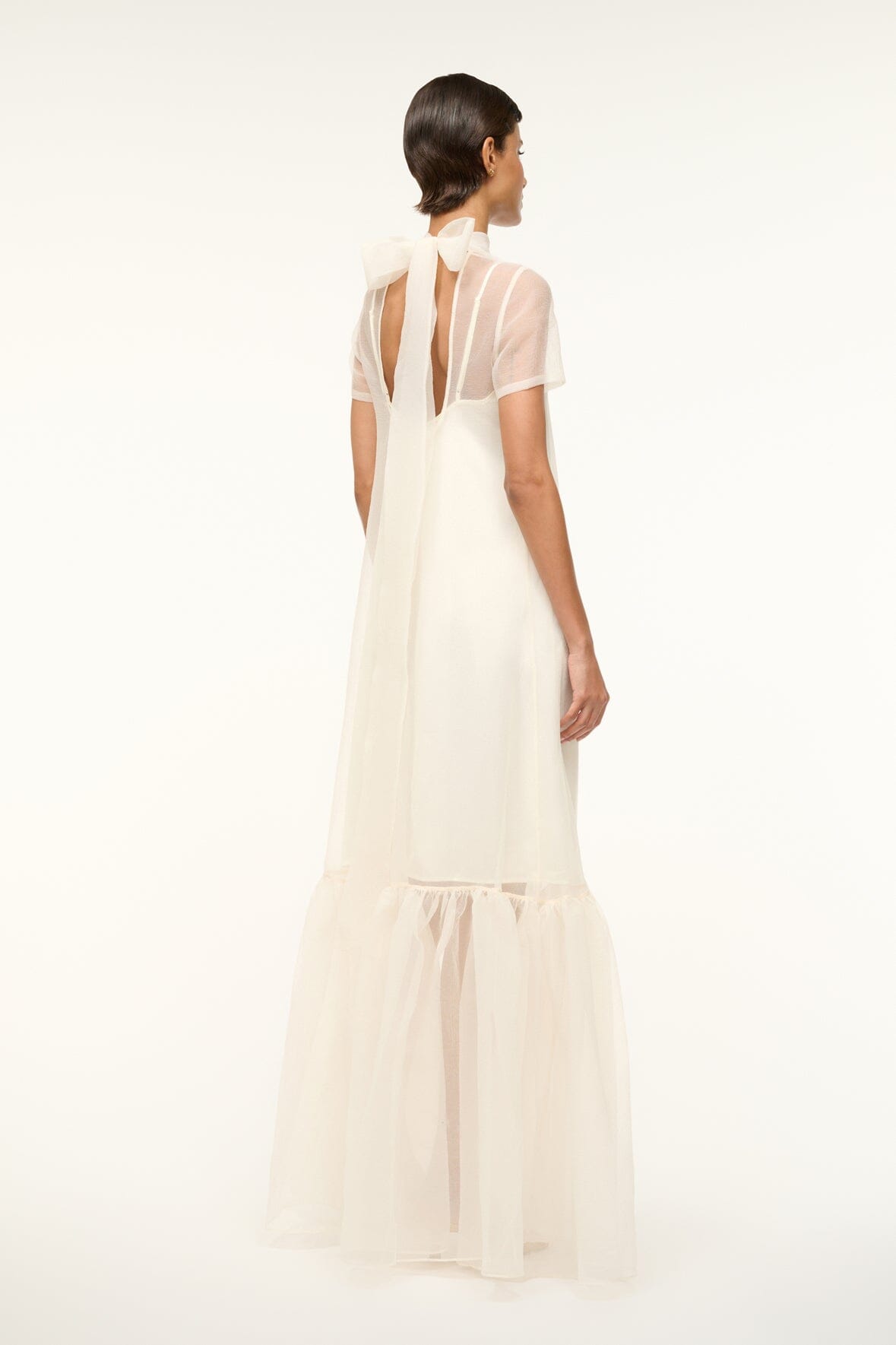 White dress back view with open back, thin straps, and tied waist