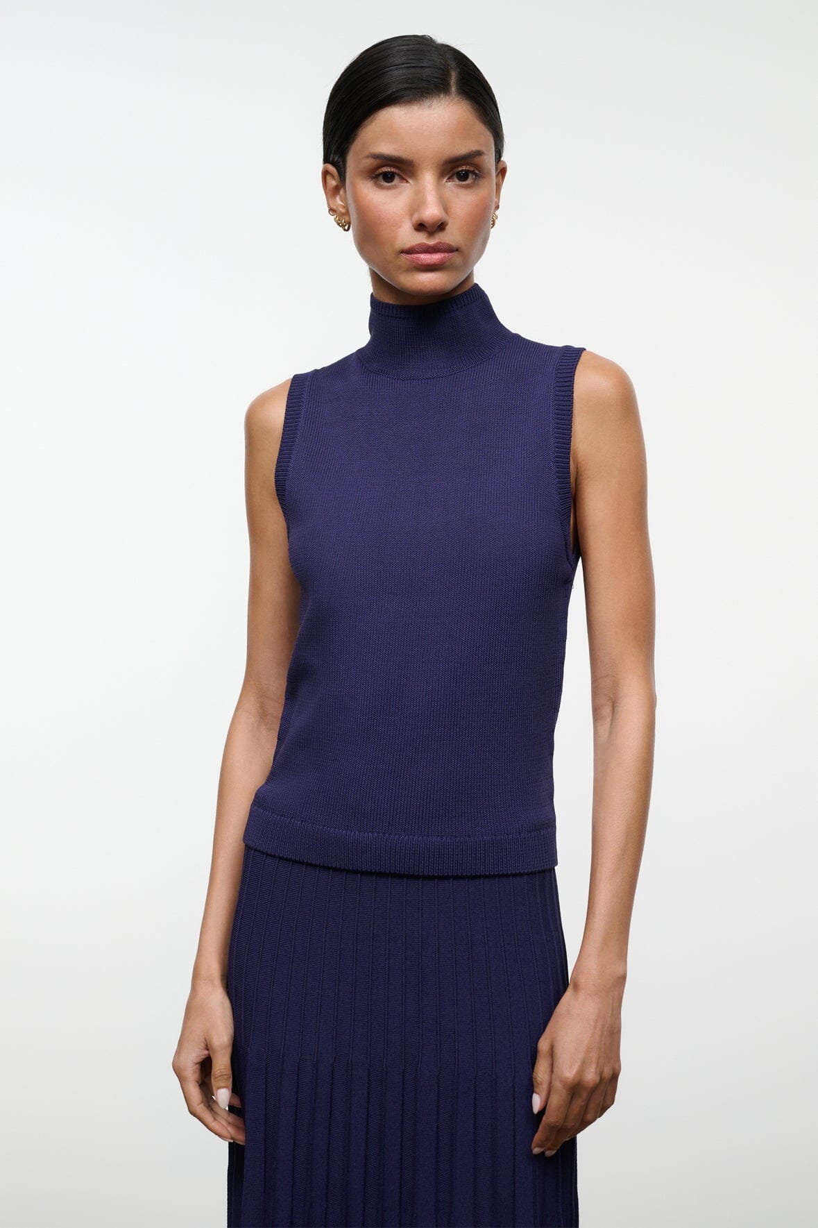 Sleeveless navy turtleneck knit top with ribbed hem and fitted waist