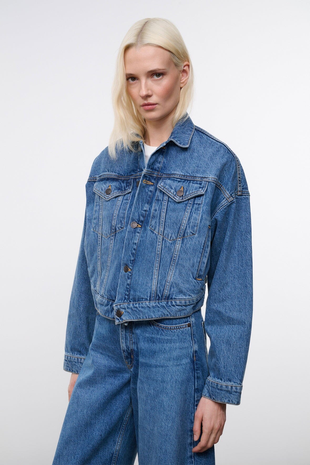 Vintage-wash denim jacket with chest pockets and button cuffs, side view