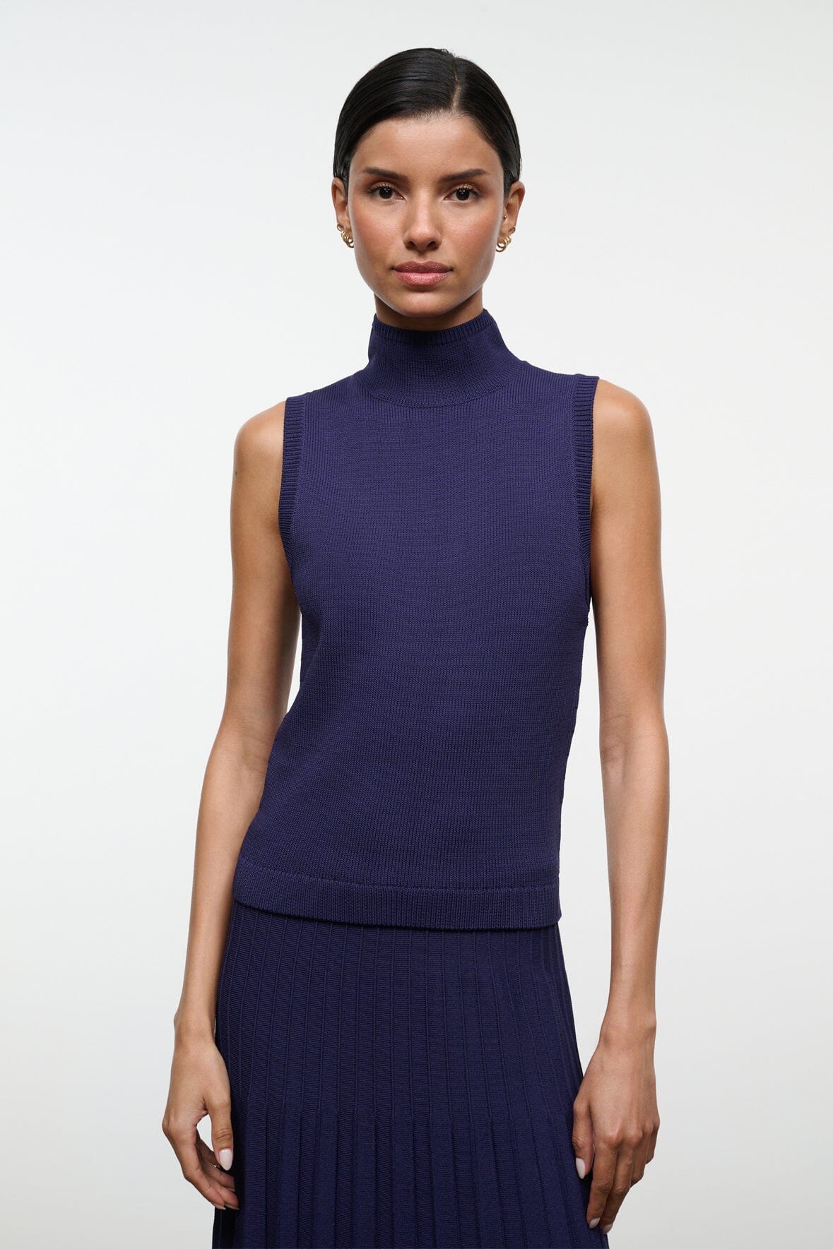 Front view of navy sleeveless turtleneck knit top with ribbed trim