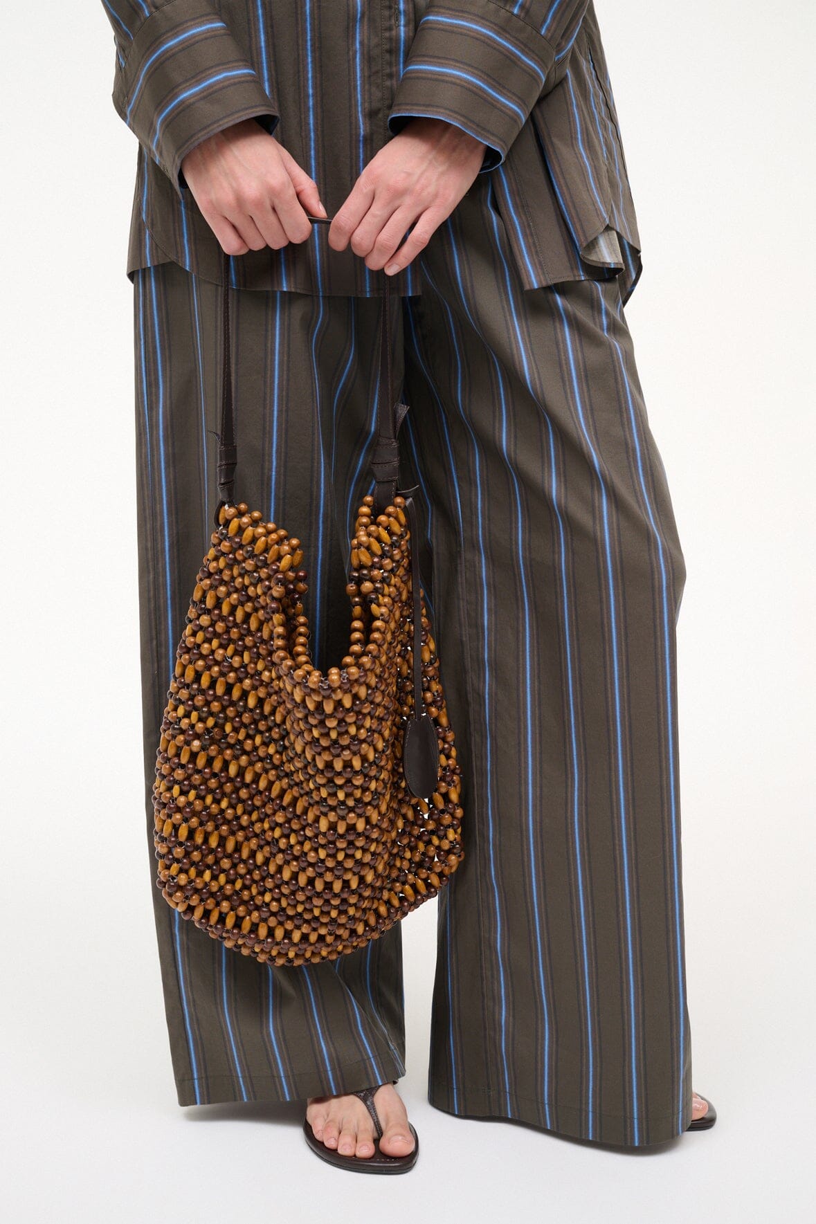 Multi wood bead hobo bag with black strap handles and black cord detail at the top
