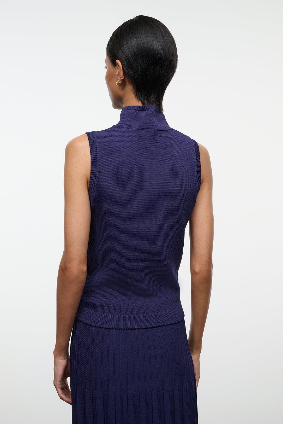 Back view of navy sleeveless turtleneck knit top with ribbed neckline