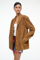 Tan suede jacket with notched lapels and chest pockets, model side view