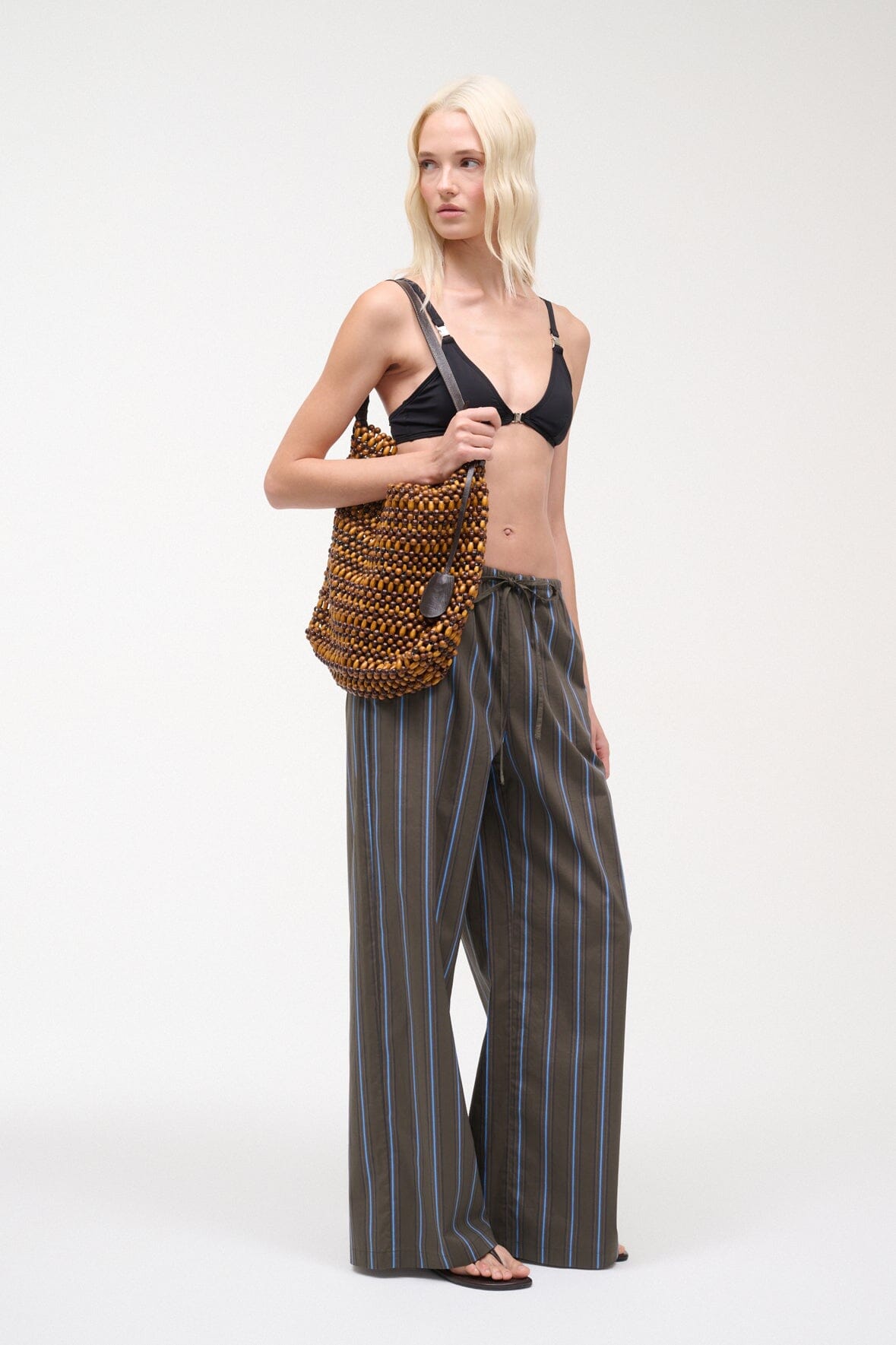 Dark vertical striped wide-leg pants with drawstring waist, ankle-length.