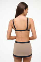 Women’s taupe swim skirt with black waistband and black edge trim, back view