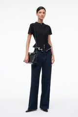 Black leather cuff clutch bag with silver-tone clasp and wrist strap, held by model