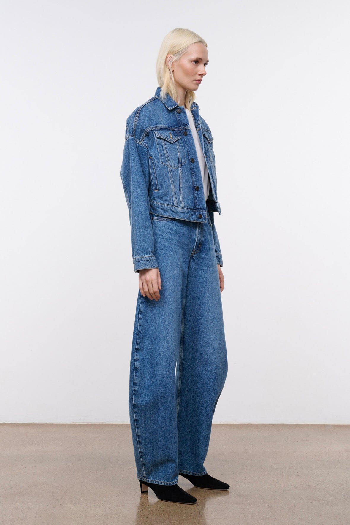 Vintage-wash denim jacket with chest pockets and long sleeves, side profile