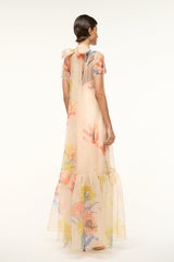 Back view peach floral maxi dress with sheer sleeves and flowing tiered skirt