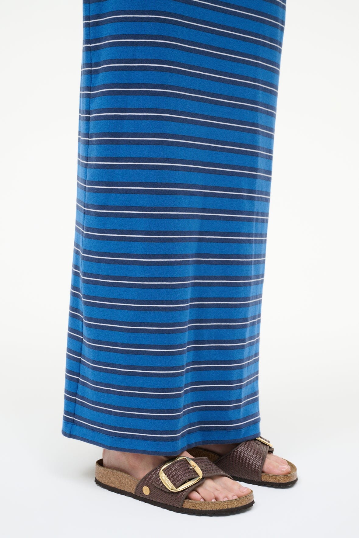 Raffia slide sandal with dark brown straps, tan footbed, and gold buckle at ankle