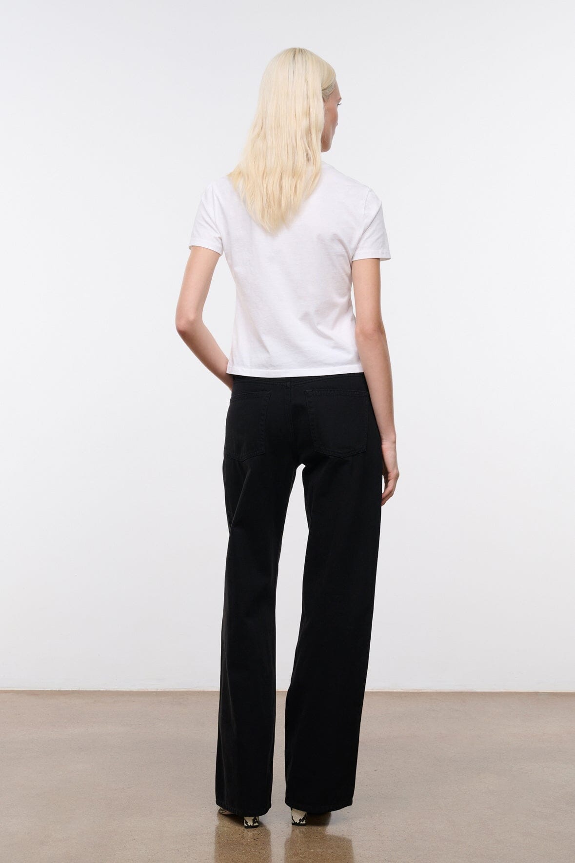 Black relaxed jeans with wide leg, belt loops, front fly, and front pockets