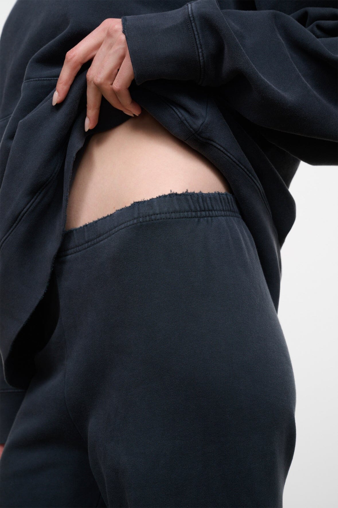 Washed black terry sweatpants with elastic waistband and wide straight legs
