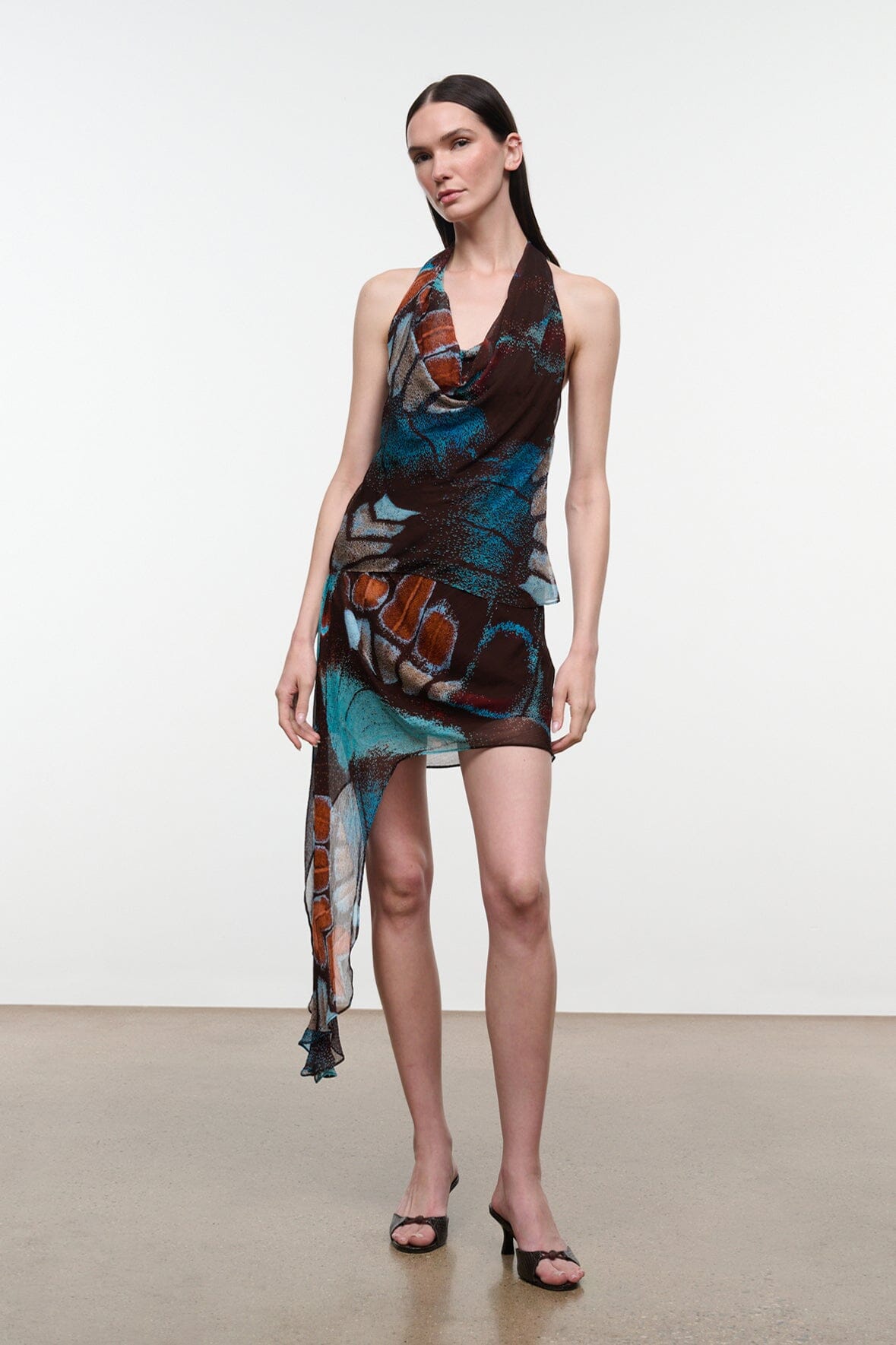 Short asymmetrical mini skirt with long sheer drape; dark brown butterfly print, teal and orange.