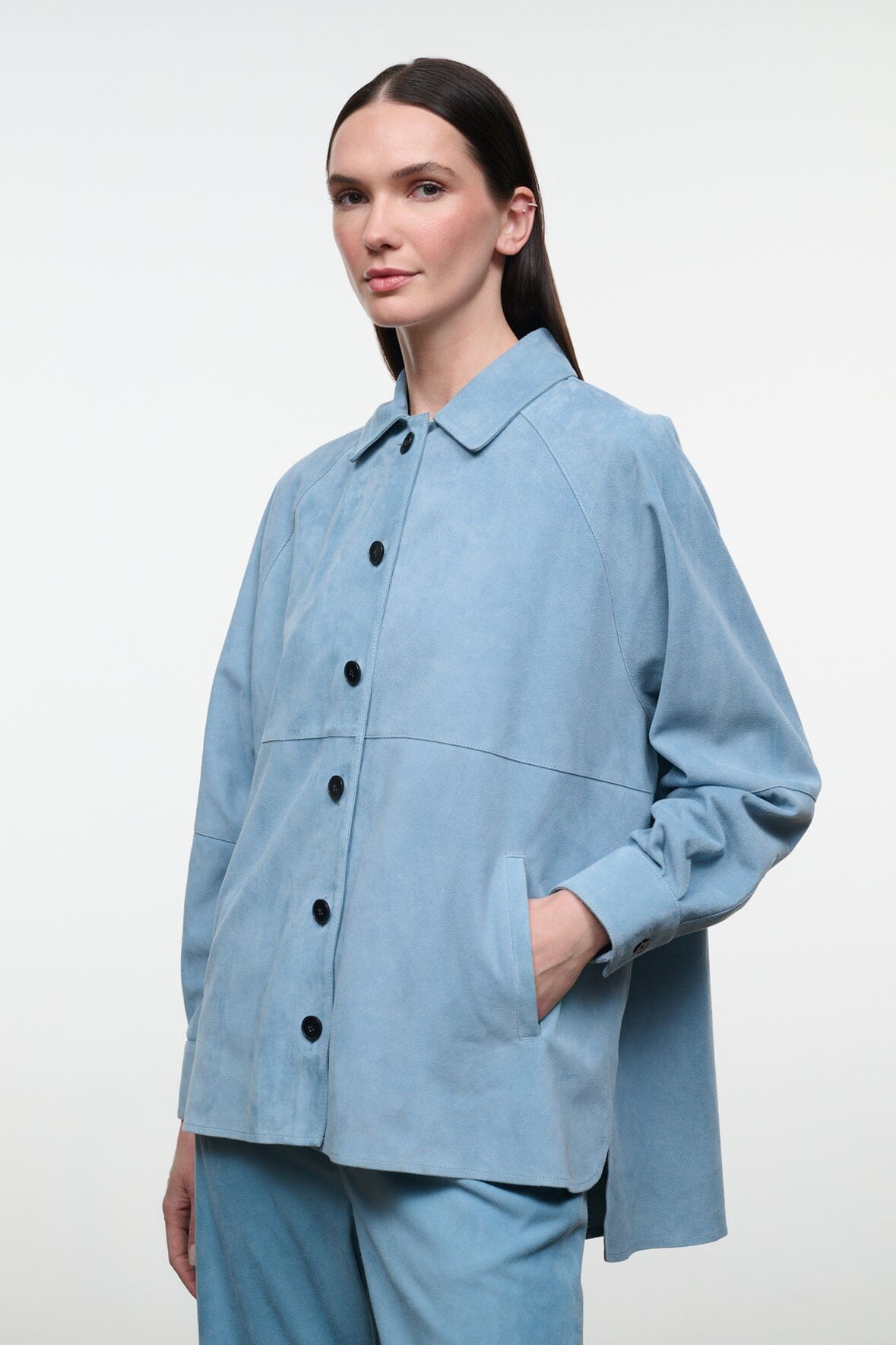 Sky-blue suede shirt with point collar and black button placket; long sleeves, patch pocket