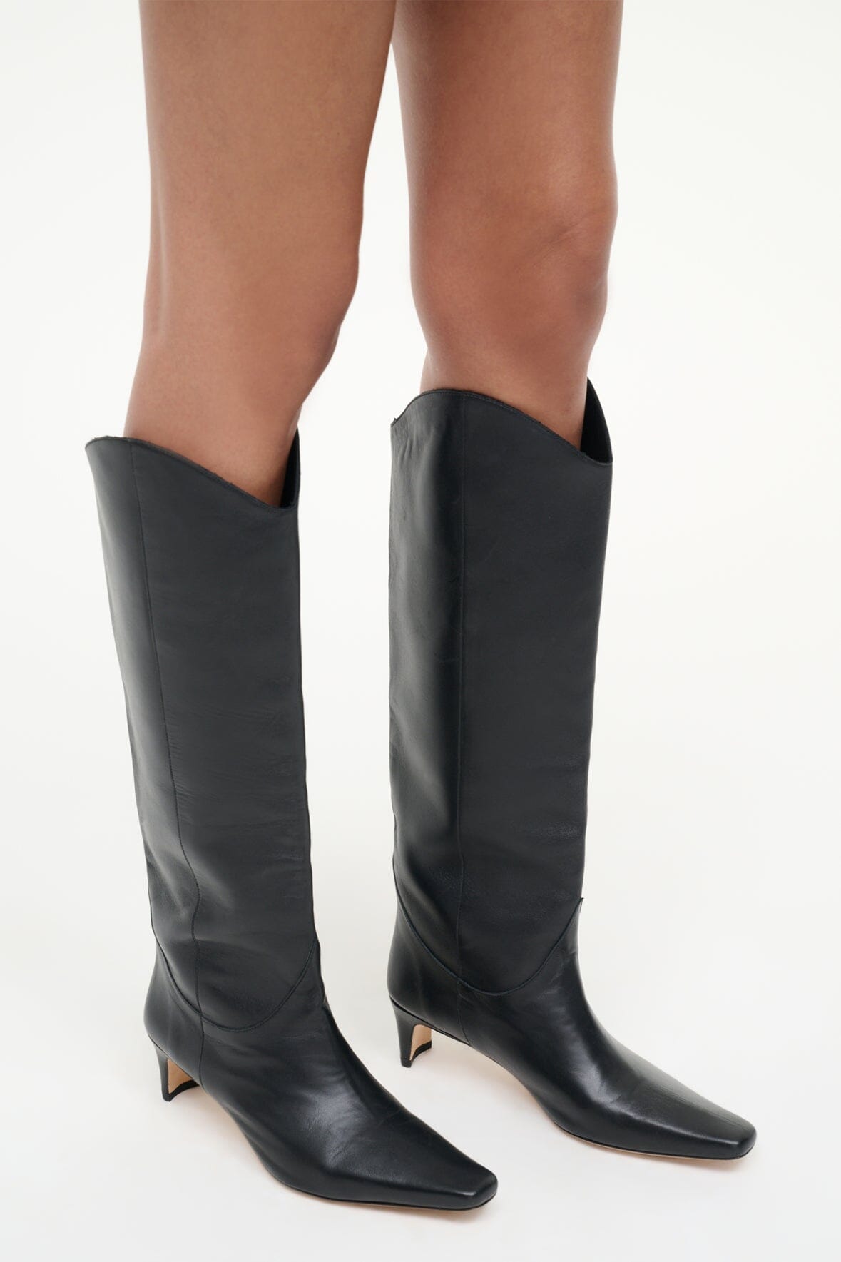 Pair of black tall western boots with pointed toe and slim stiletto heel