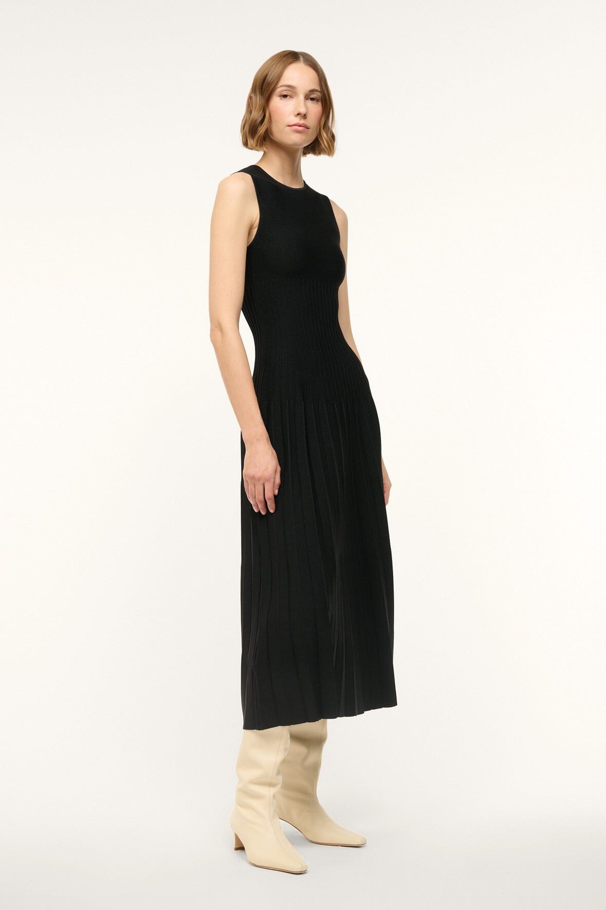 Black sleeveless midi knit dress with crew neck and pleated skirt, side view