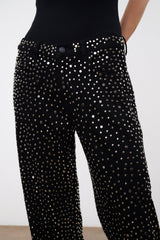 Black studded wide-leg jeans with front pocket area and button detail.