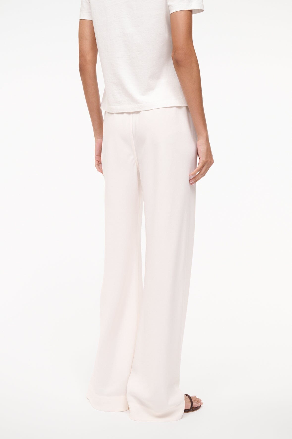 Ivory wide-leg pants with soft drape and a simple, clean hemline.
