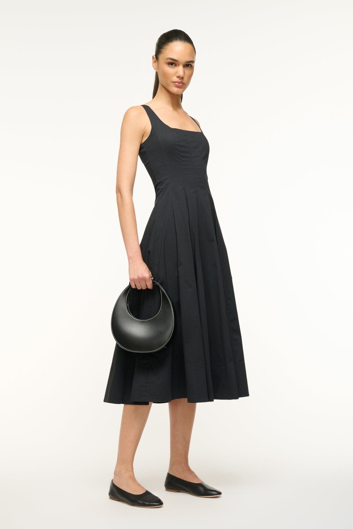Black mini moon bag worn across front on shoulder strap